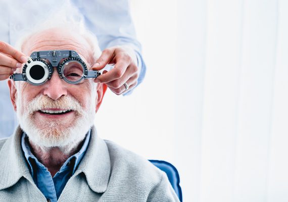 Portrait of a happy mature male patient undergoing vision check with special ophthalmic glasses